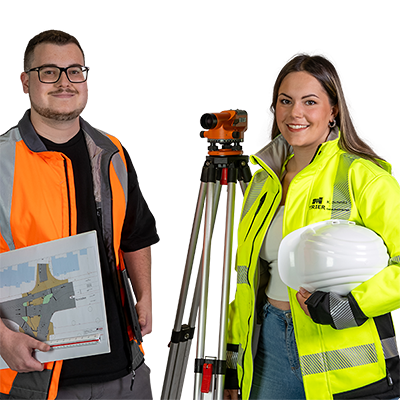 Ein Student und eine Studentin in Arbeitskleidung mit Helm und Ausrüstung